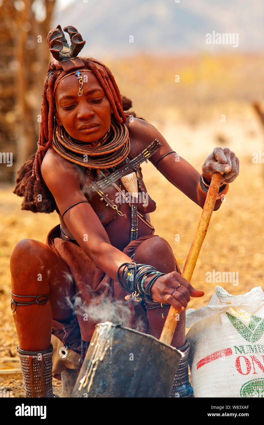 Donna Himba cucinare il suo cibo, Epupa Falls, Namibia Foto Stock