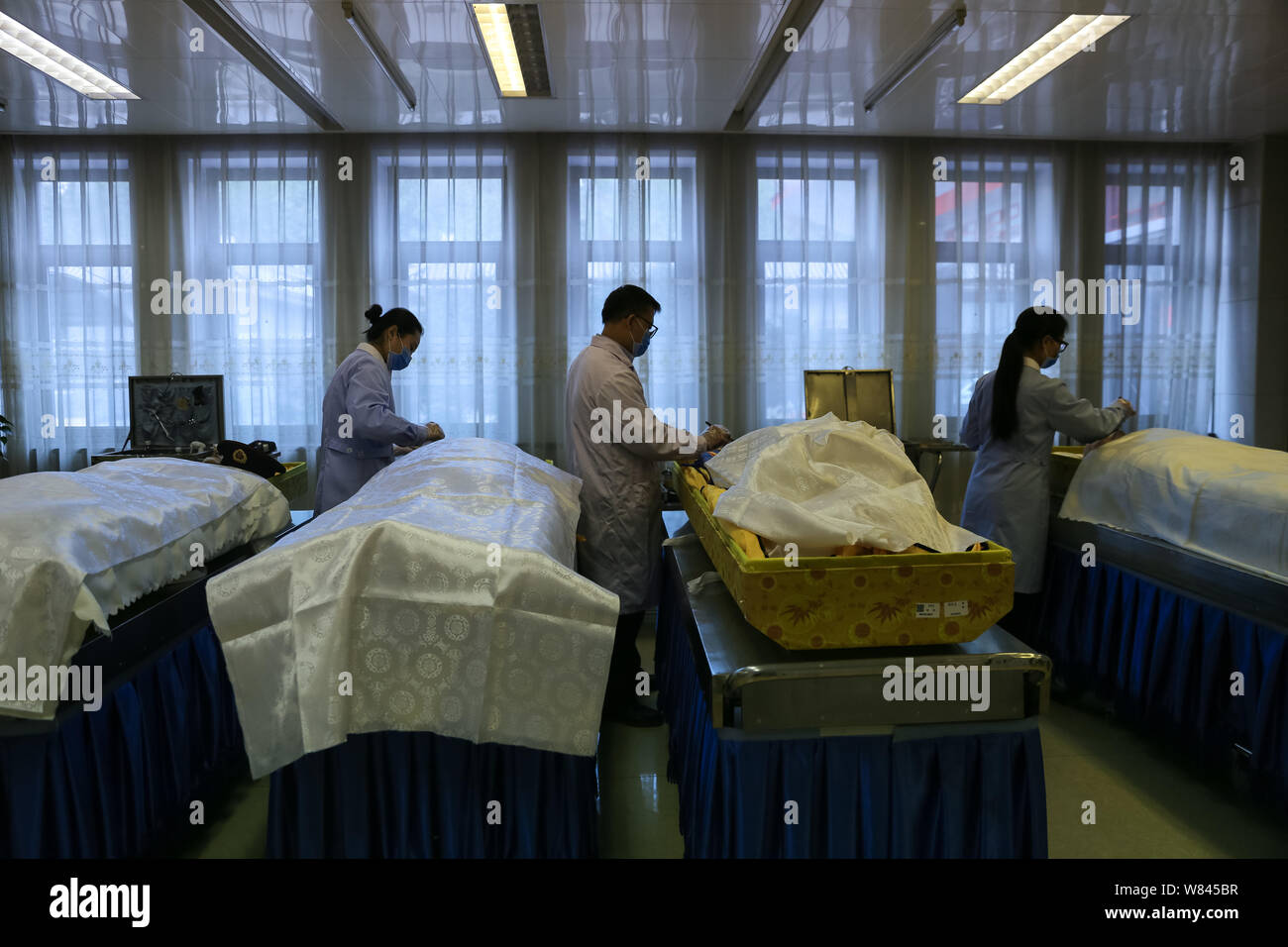 Encoffiners cinesi stanno facendo per i corpi dei morti in Babaoshan funerali a casa a Pechino in Cina, 17 novembre 2016. Qu Jie e tre altri Foto Stock