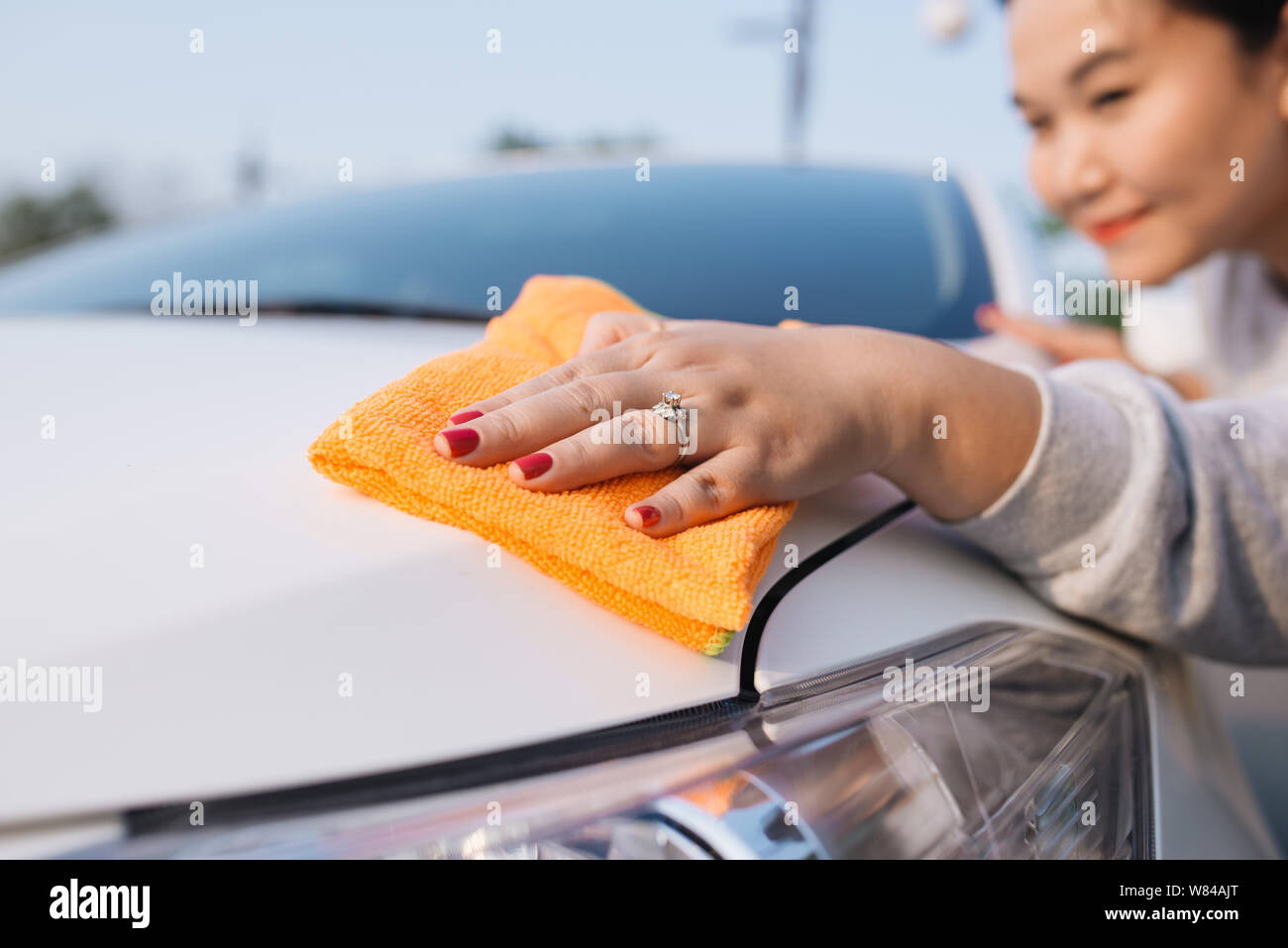Una donna auto pulizia con panno in microfibra, auto che dettaglia (o valeting) concetto Foto Stock