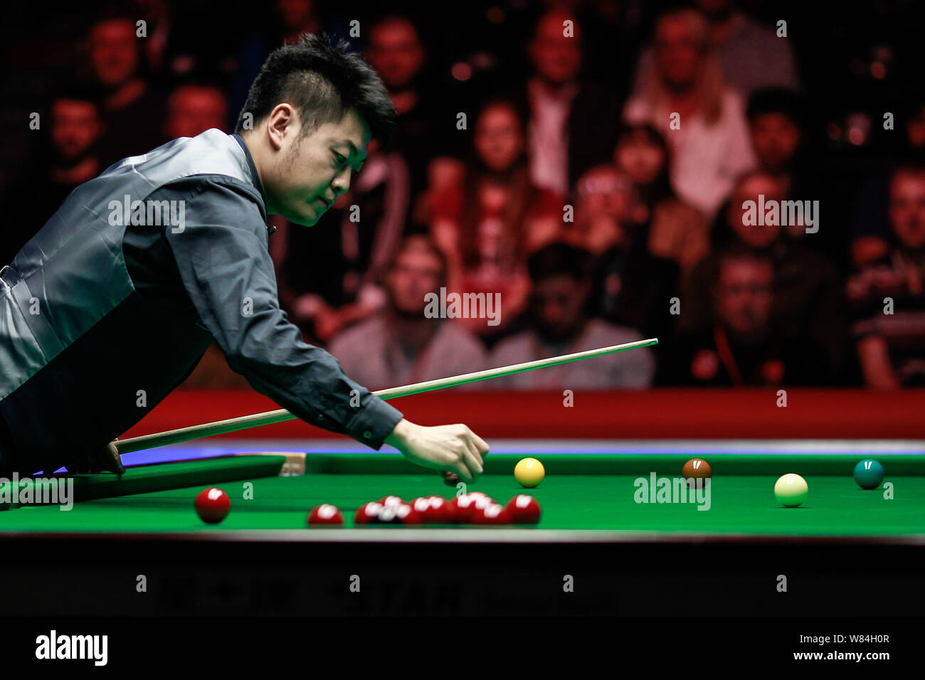 Liang Wenbo della Cina ritiene un colpo contro Judd Trump di Inghilterra in loro corrispondenza finale durante l'inglese Open 2016 torneo di biliardo in Manchester Foto Stock