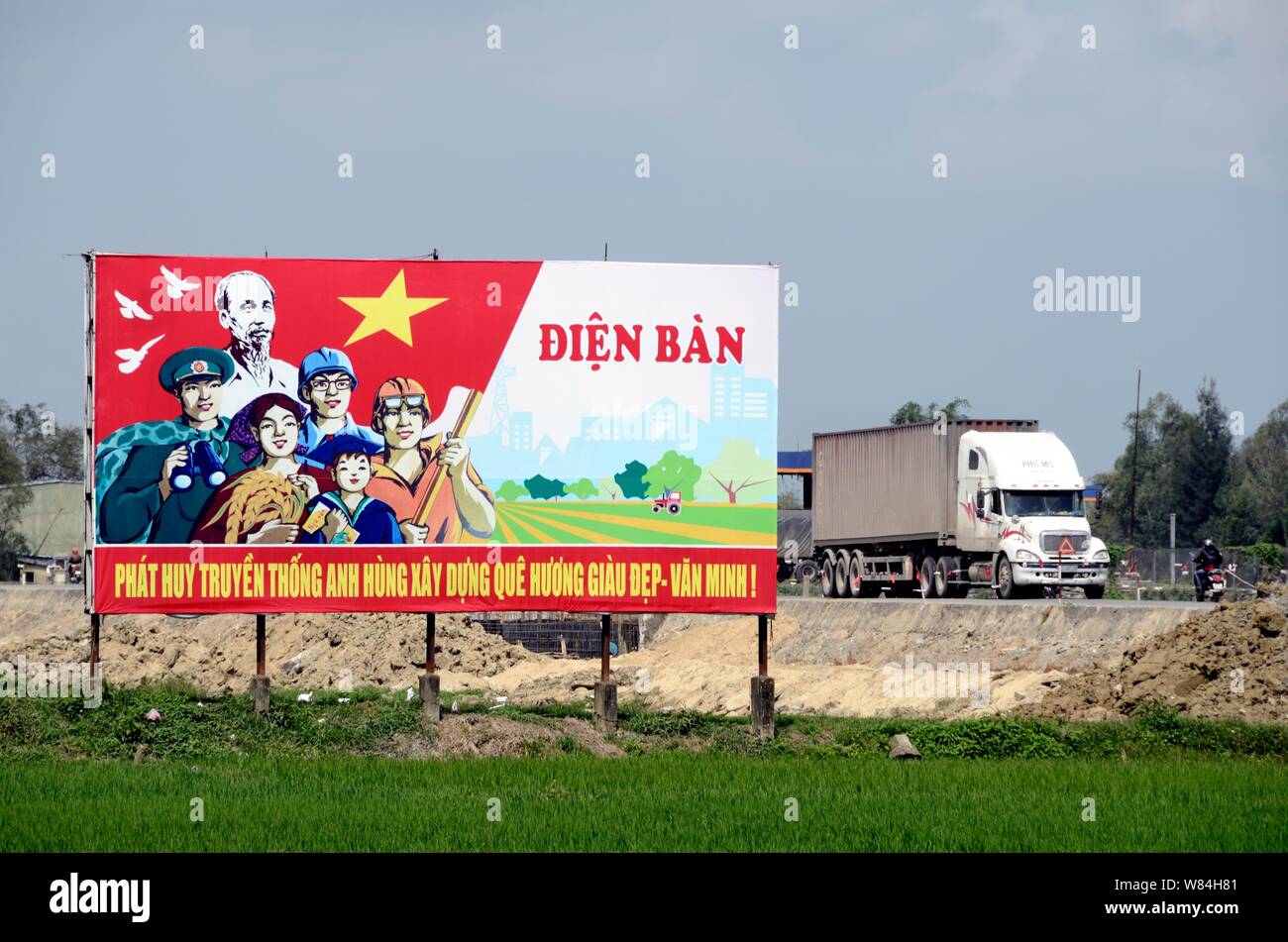 Un vecchio American carrello passa una propaganda comunista poster in Vietnam Foto Stock