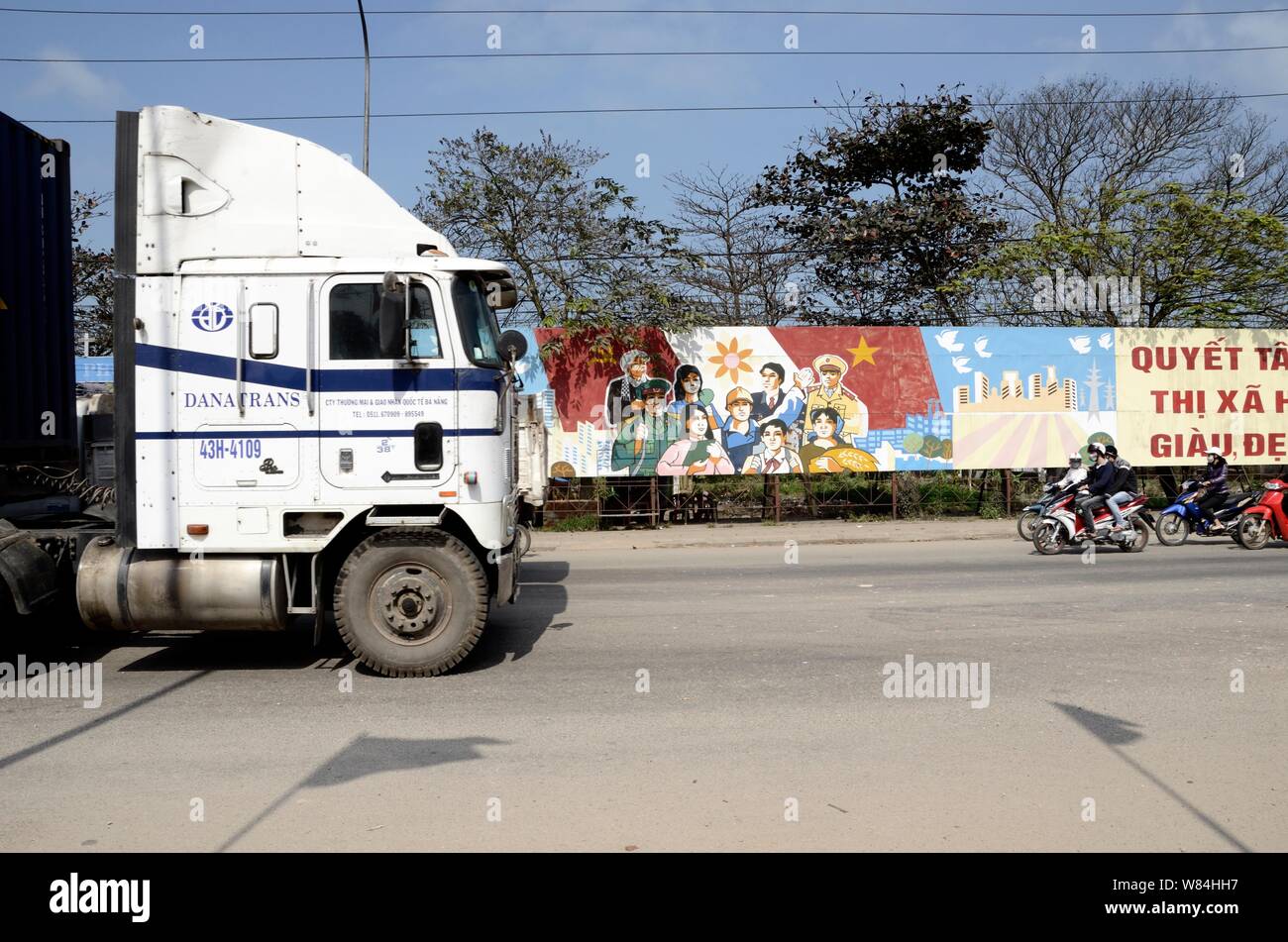 Un vecchio American carrello passa una propaganda comunista poster in Vietnam Foto Stock