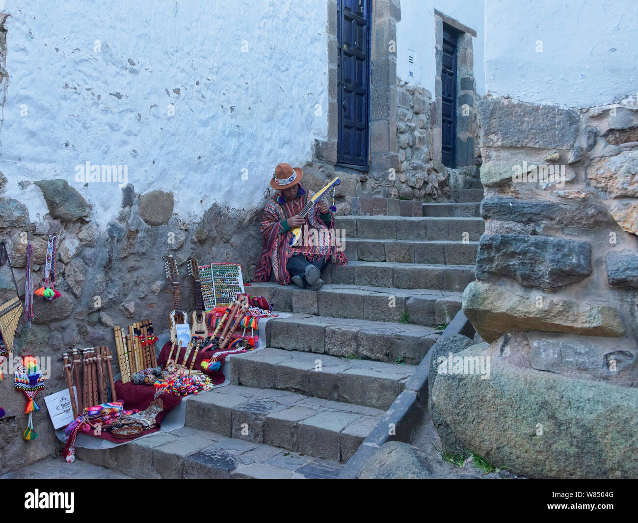Musicista andina a giocare il suo charango sulle stradine della città di Cusco, Perù Foto Stock