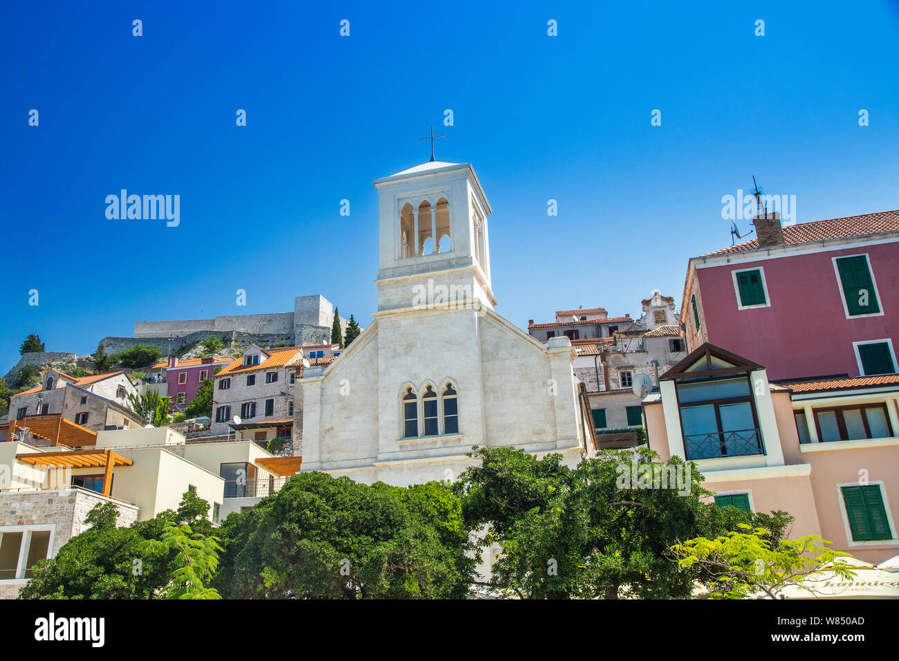 Sibenik, Croazia, Europa, piccola chiesa di pietra nella città vecchia, fortezza in background Foto Stock