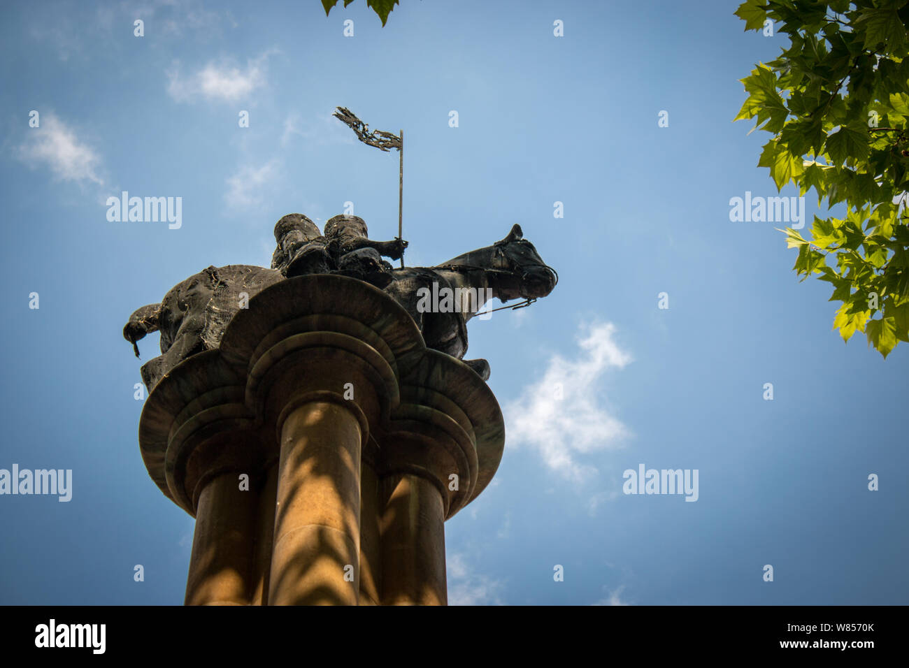 Una statua di due uomini che condividono uno cavallo per rappresentare il voto di povertà presi dai Cavalieri Templari è montato sulla parte superiore di una colonna appena al di fuori del tempio la Chiesa. Foto Stock