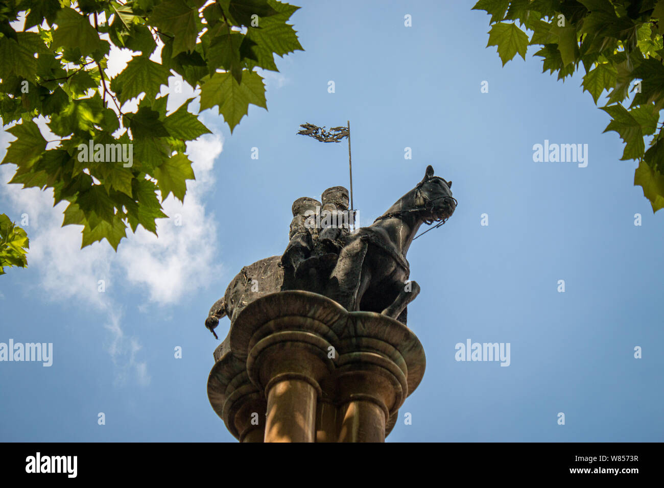 Una statua di due uomini che condividono uno cavallo per rappresentare il voto di povertà presi dai Cavalieri Templari è montato sulla parte superiore di una colonna appena al di fuori del tempio la Chiesa. Foto Stock