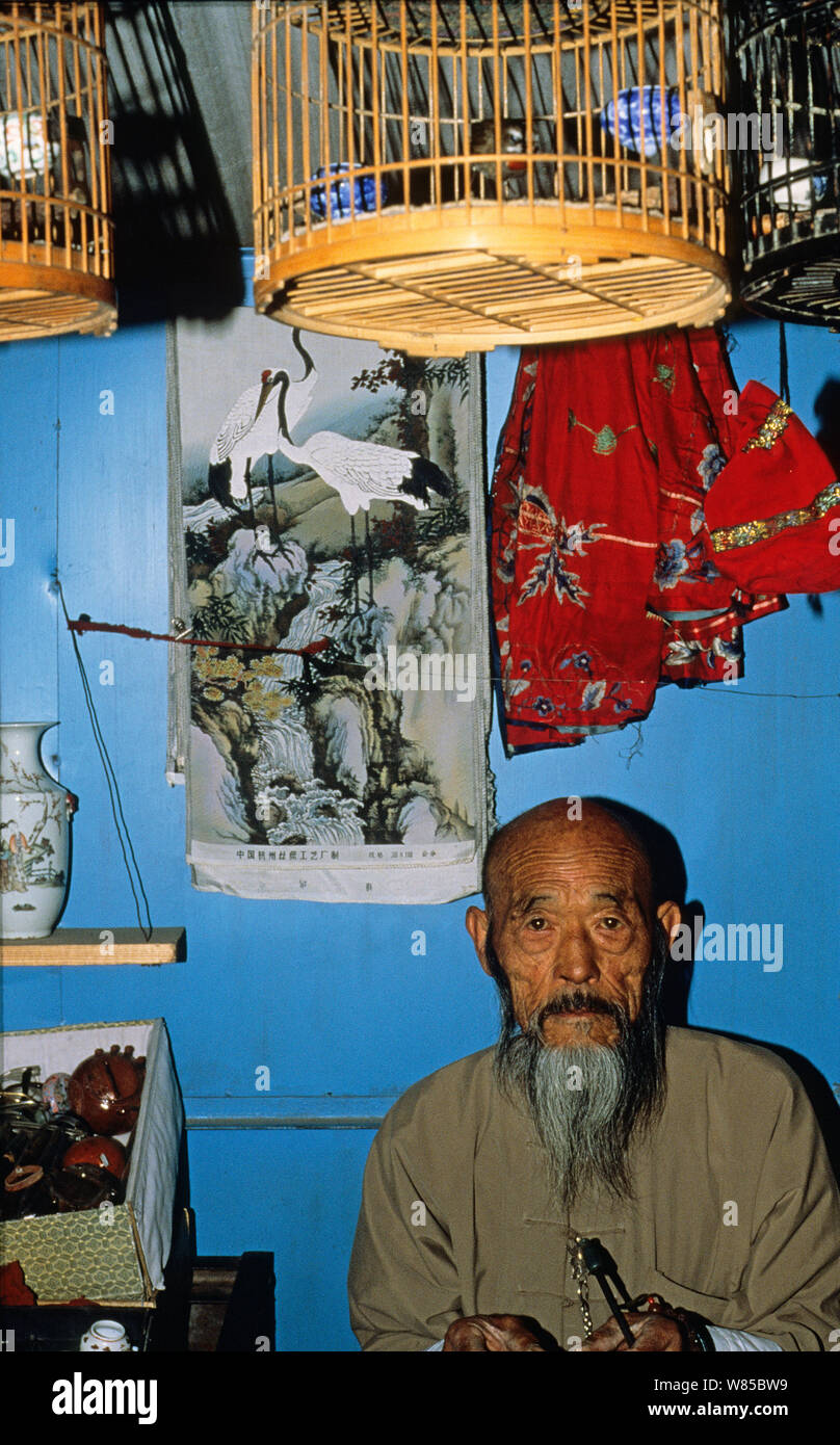 Commerciante di uccelli con Rubythroat siberiano (Luscinia calliope) a Pechino Bird Market, Cina, 1993. Foto Stock
