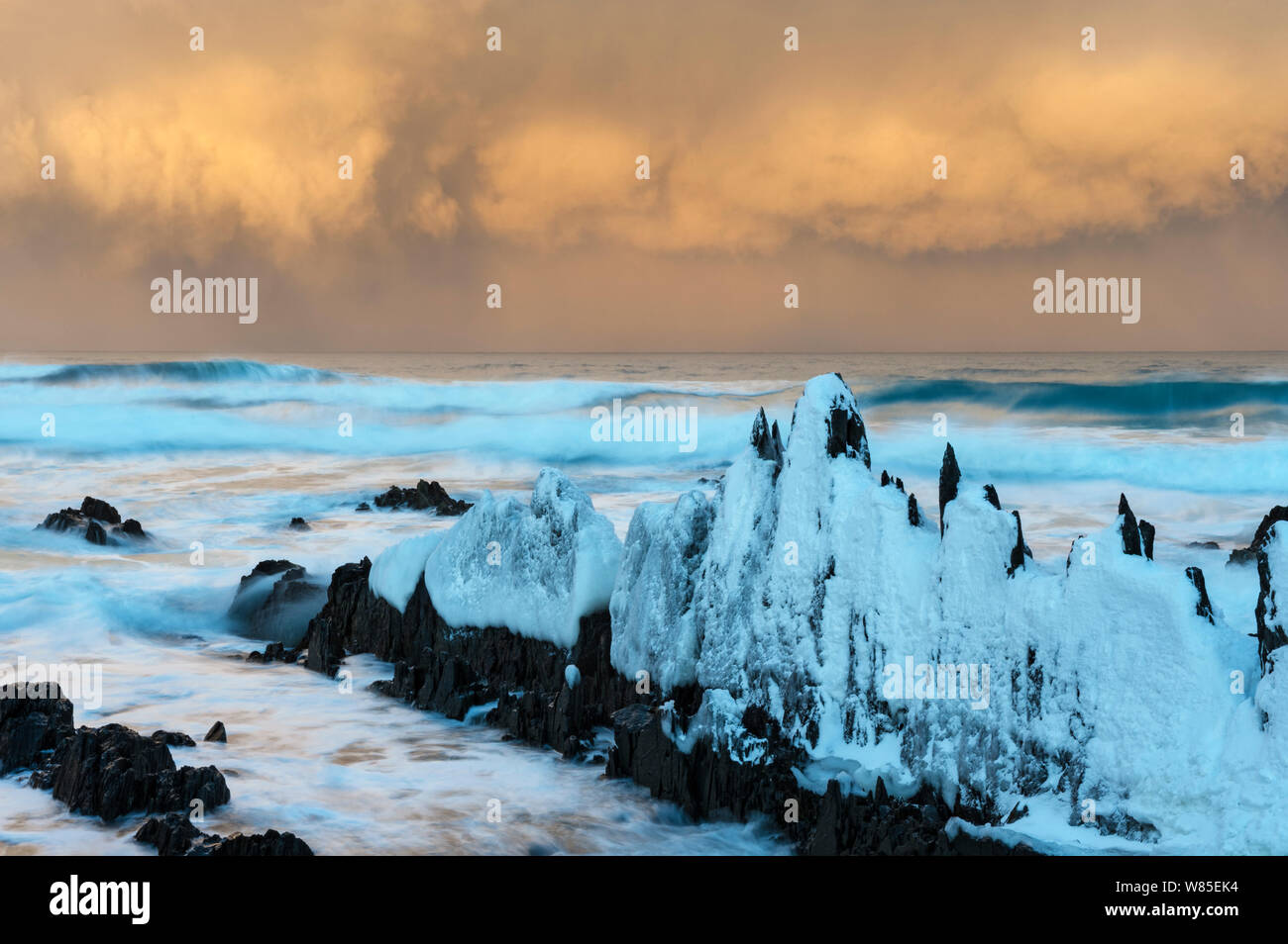 Formazioni di pietra nel paesaggio invernale, con neve nuvole sopra il mare, Sandfjorden, Berlevag comune, Varanger-penisola, Finnmark, Norvegia. Marzo 2010 Foto Stock