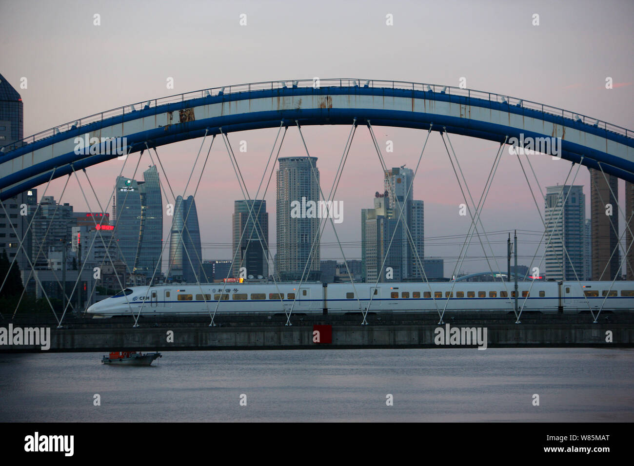 --FILE--un CRH (Cina ferrovia ad alta velocità) treno proiettile passa attraverso un ponte ferroviario oltre il Fiume Fenghua nella città di Ningbo, est della Cina di Zhejiang pro Foto Stock