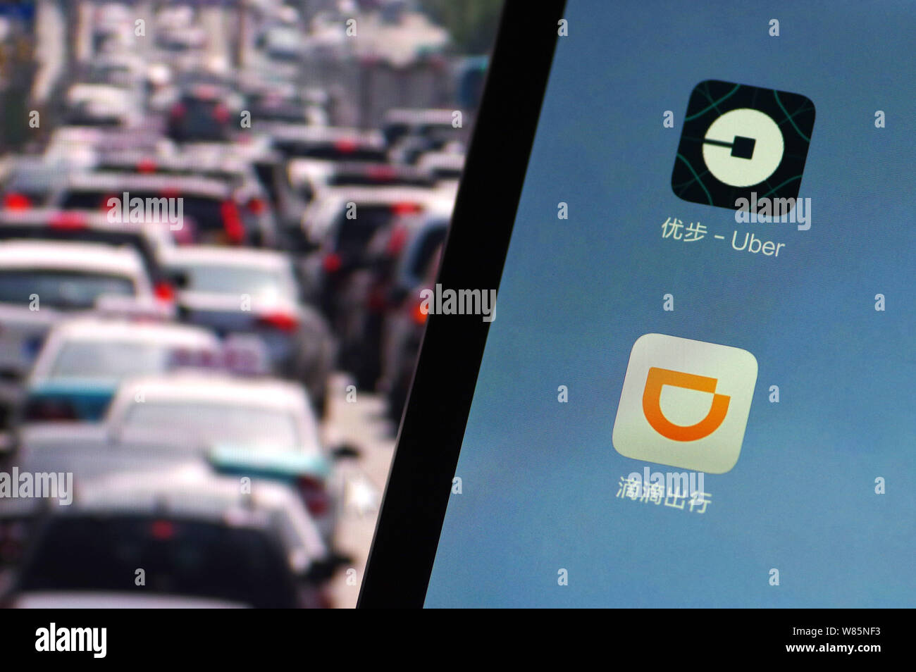 --FILE--un cinese telefono cellulare utente guarda le icone delle applicazioni mobile di taxi-salutando apps Didi Chuxing, inferiore e Uber sul suo smartphone in Jina Foto Stock
