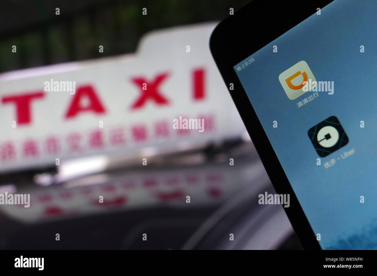 --FILE--un cinese telefono cellulare utente guarda le icone delle applicazioni mobile di taxi-salutando apps Didi Chuxing, superiore e Uber sul suo smartphone in Jina Foto Stock