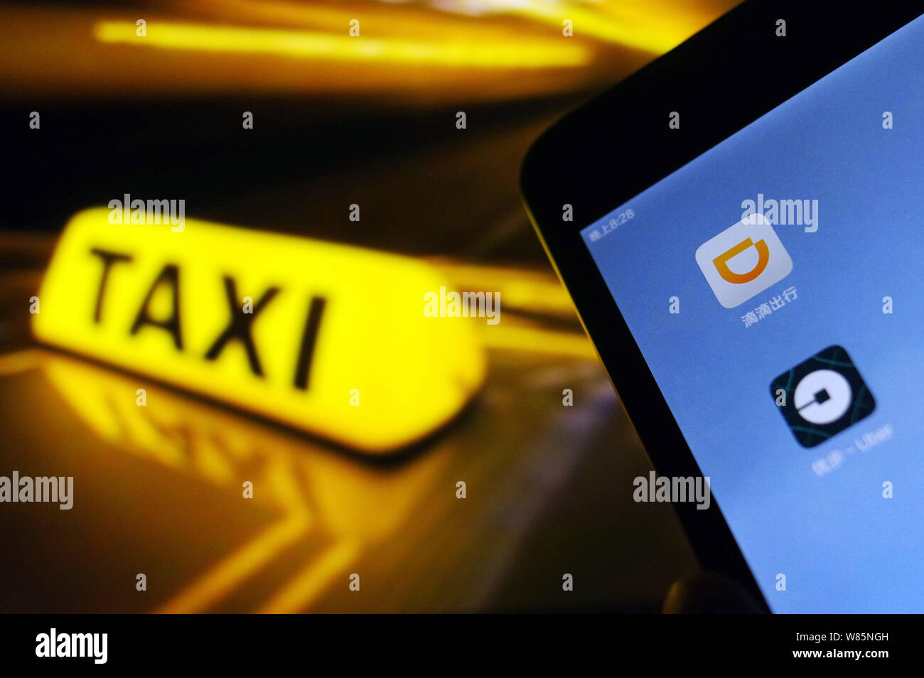 --FILE--un cinese telefono cellulare utente guarda le icone delle applicazioni mobile di taxi-salutando apps Didi Chuxing, superiore e Uber sul suo smartphone in Jina Foto Stock