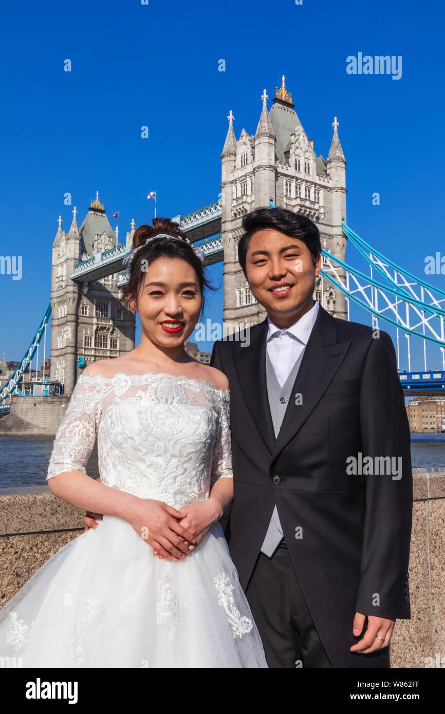 Inghilterra, Londra, il Tower Bridge, cinese giovane in Costume di nozze in piedi nella parte anteriore del Tower Bridge Foto Stock