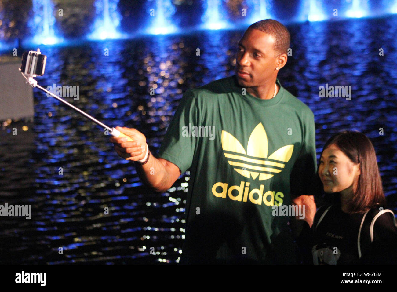 NBA star Tracy McGrady, sinistra, prendere un selfie con un ventilatore cinese durante un evento di lancio per la fontana visualizza "Lago di illusioni" a Shanghai La Felice V Foto Stock