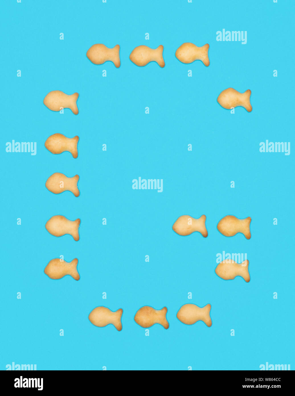 Lettera maiuscola G alfabeto latino da biscotti a forma di pesce su uno sfondo blu Foto Stock