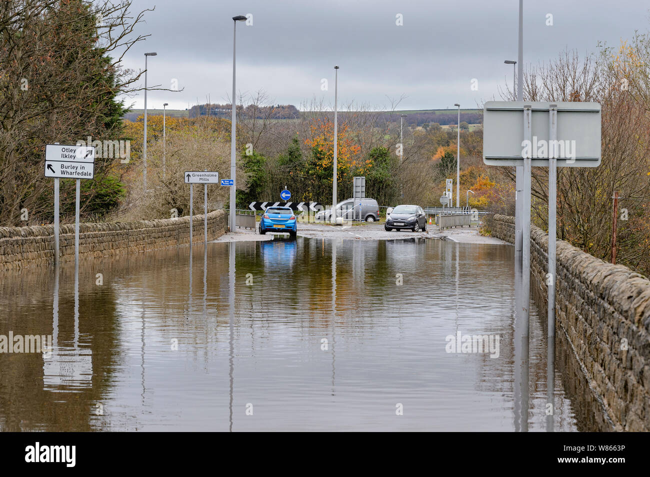 Allagamento - allagata la strada è impraticabile per le automobili come profondo acqua di inondazione rende la guida pericolosa per i veicoli - Burley in Wharfedale, nello Yorkshire, Inghilterra, Regno Unito. Foto Stock