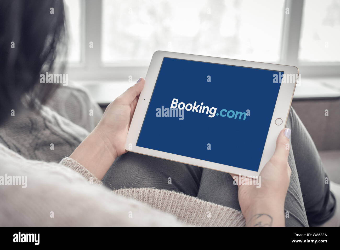 Kiev, Ukrain - 10 Febbraio 2018: Donna tramite Booking.com app su un nuovo iPad Apple Pro argento, settima generazione di iPad, sviluppato da Apple inc Foto Stock