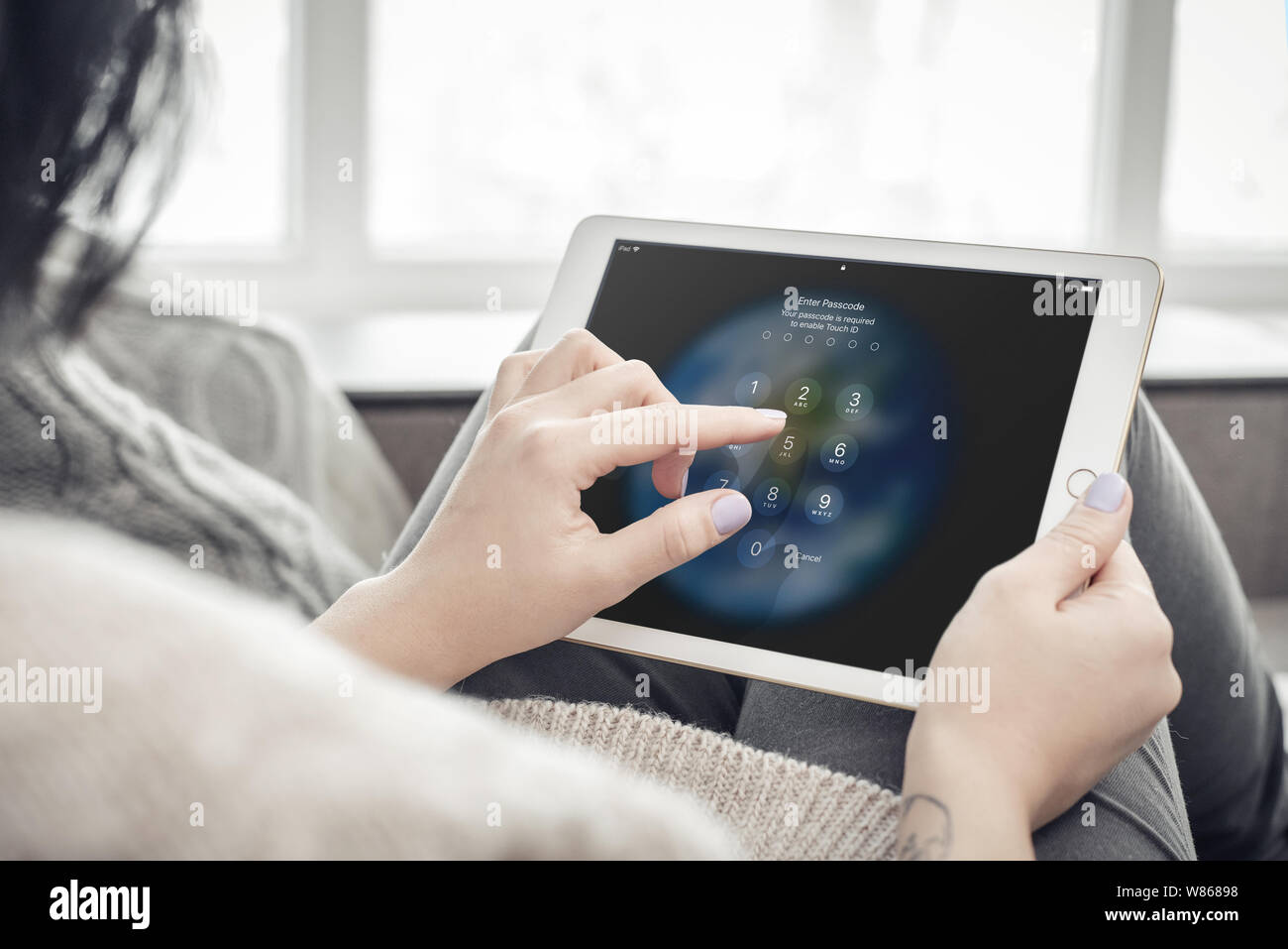 Kiev, Ukrain - 10 Febbraio 2018: Donna tenendo un un nuovo iPad di Apple Pro argento e immettere il codice di accesso, , 7 ° generazione di iPad, sviluppato da Apple Foto Stock