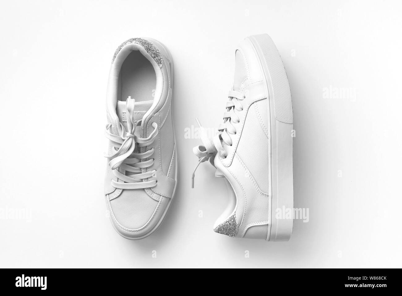 Bianco Pelle sneakers su sfondo bianco. Coppia di moda bianco alla moda scarpe da ginnastica o sneakers con copia spazio per il testo o il design. Tettuccio di colpo di Foto Stock