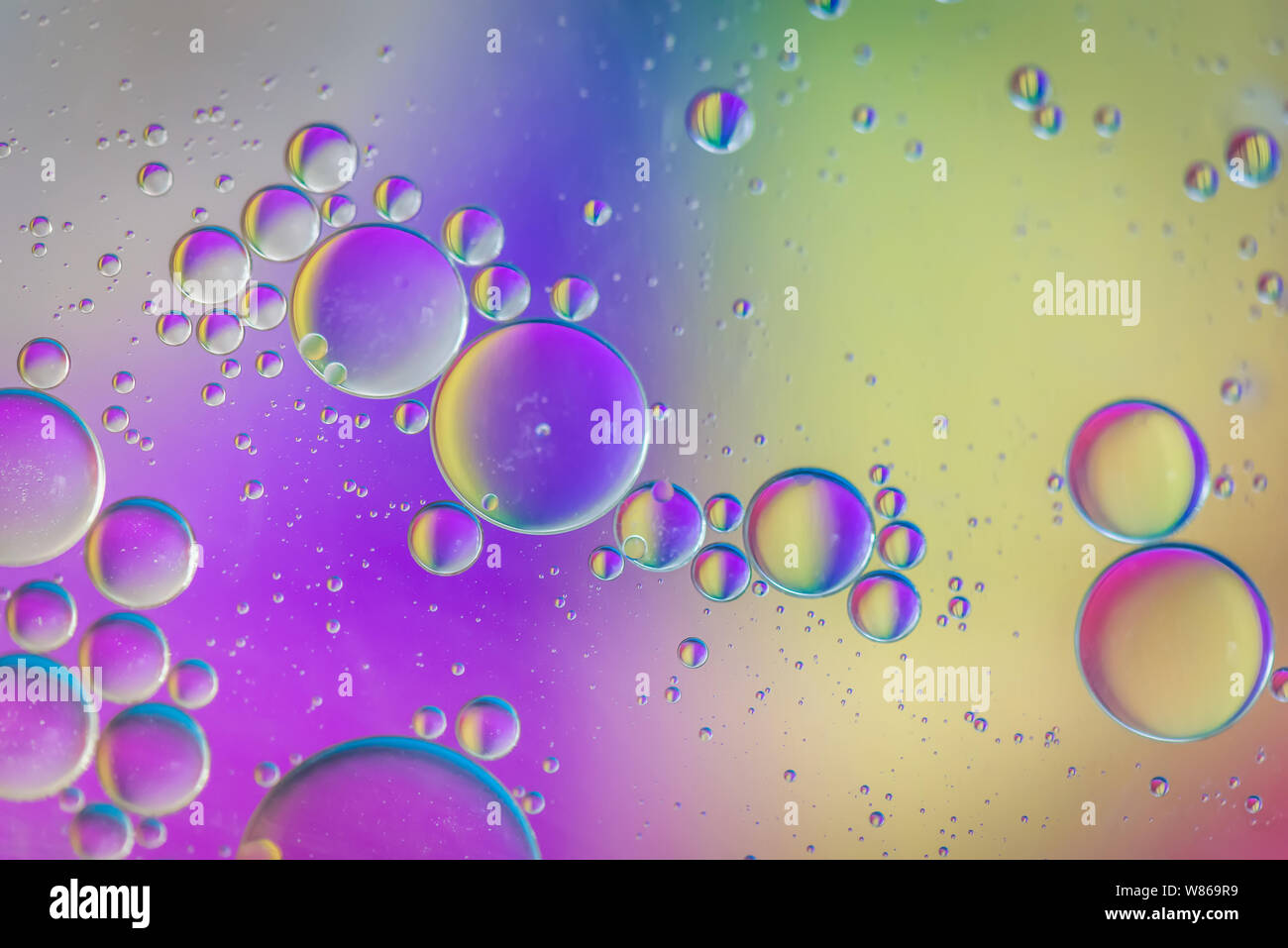 Gocce di olio in acqua. Abstract pattern psichedelici immagine multicolore. Sfondo astratto con variopinti colori gradiente. DOF. Foto Stock