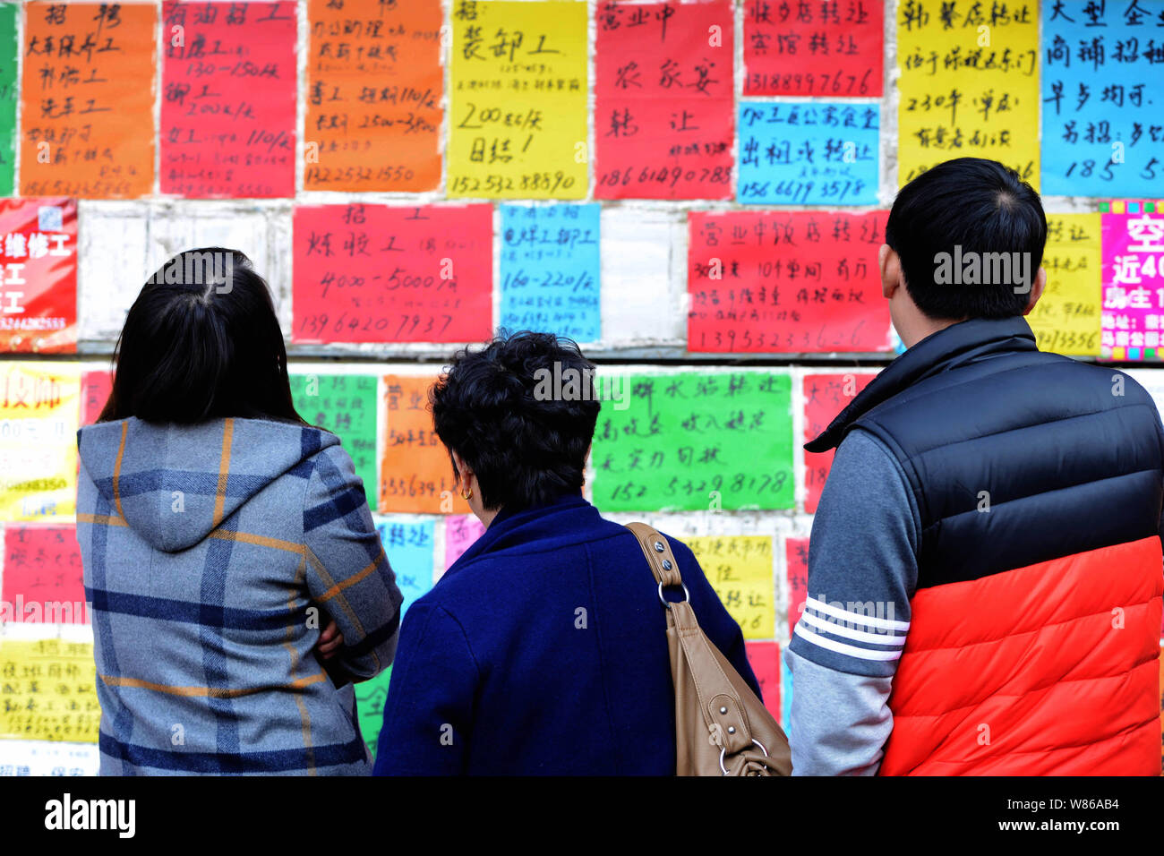 --FILE--Cinese in cerca di lavoro Leggi assunzione info ad un mercato del lavoro nella città di Qingdao, Cina orientale della provincia di Shandong, 24 febbraio 2016. Della Cina di urban u Foto Stock