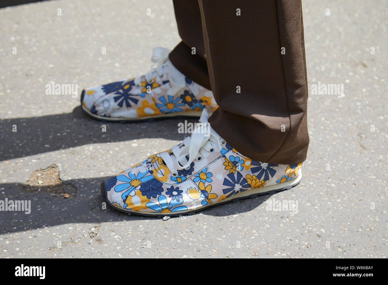 Milano, Italia - 15 giugno 2019: l'uomo con motivi floreali sneakers e pantaloni marrone prima Marni fashion show, la Settimana della Moda Milanese street style Foto Stock
