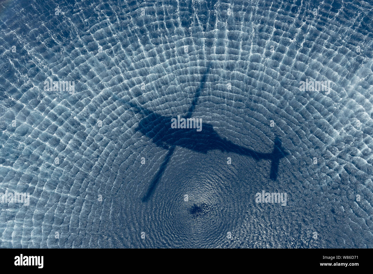 L'ombra di un HH-60G Pave Hawk oltre oceano, luglio 25, 2019, fuori di Kadena Air Base, Giappone. La HH-60G Pave Hawk è in grado di eseguire le operazioni di tempo di pace come la ricerca civile e di salvataggio di emergenza e di evacuazione di medicina aeronautica, soccorso, aiuti internazionali e attività antidroga. (U.S. Air Force foto di Airman 1. Classe Matteo Seefeldt) Foto Stock