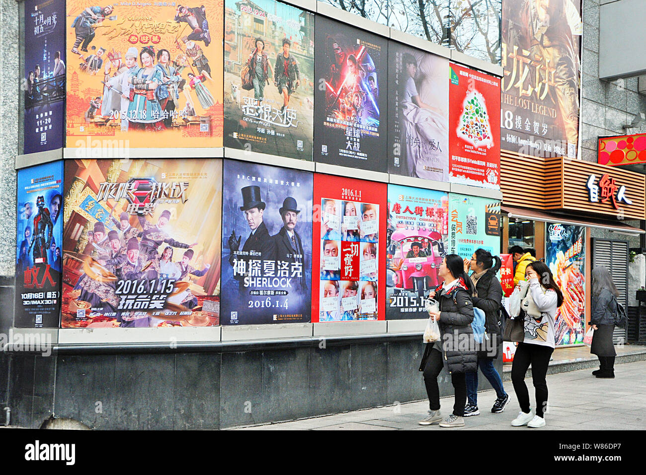 --FILE--pedoni a piedi passato manifesti di film in un cinema in Cina a Shanghai, 7 gennaio 2016. Film locali hanno conservato una posizione dominante con otto di th Foto Stock