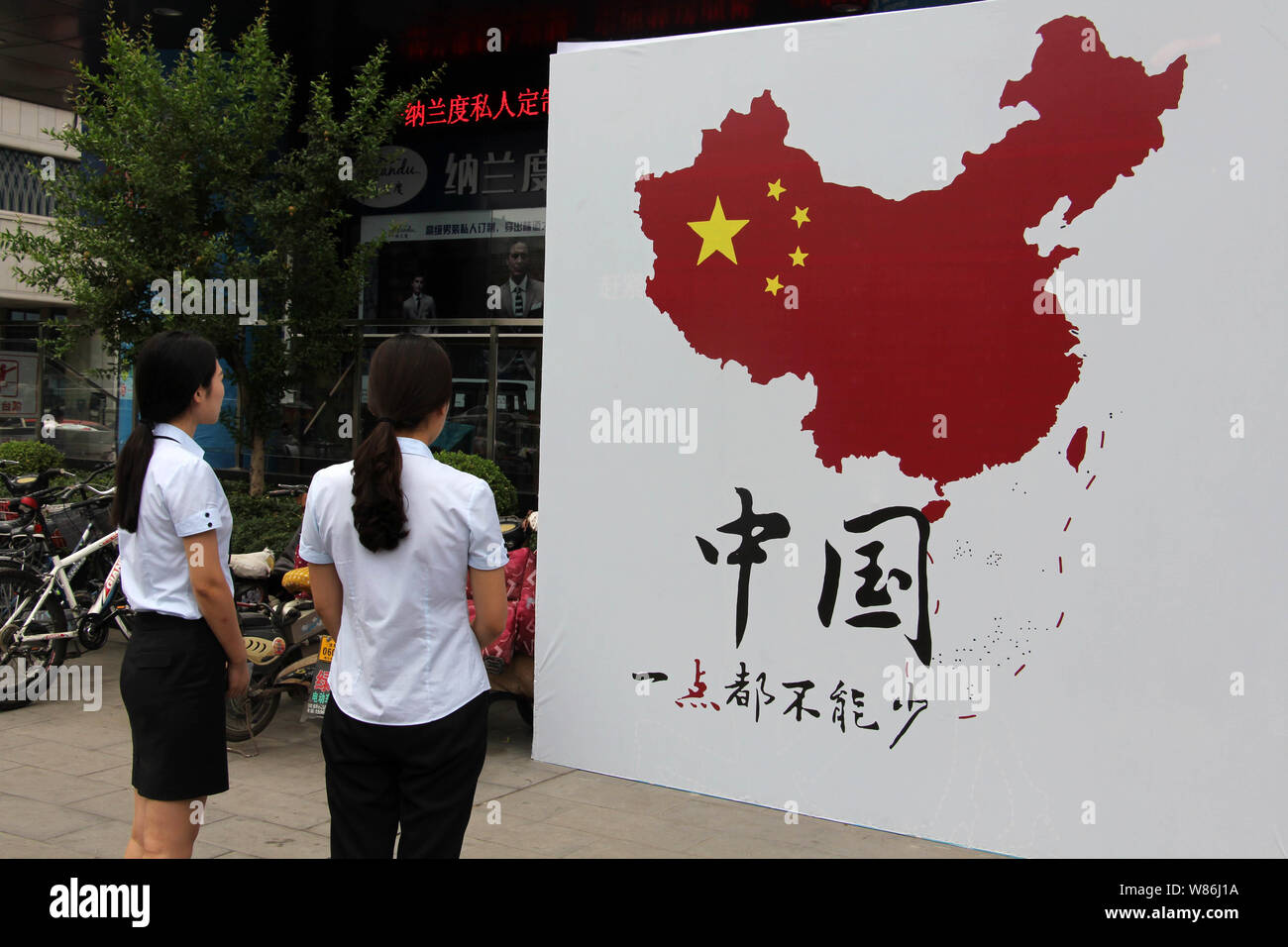 Pedoni guarda una foto che mostra la Cina del territorio su una strada nella città di Weifang, est della Cina di provincia di Shandong, 14 luglio 2016. Cina giurò di ta Foto Stock