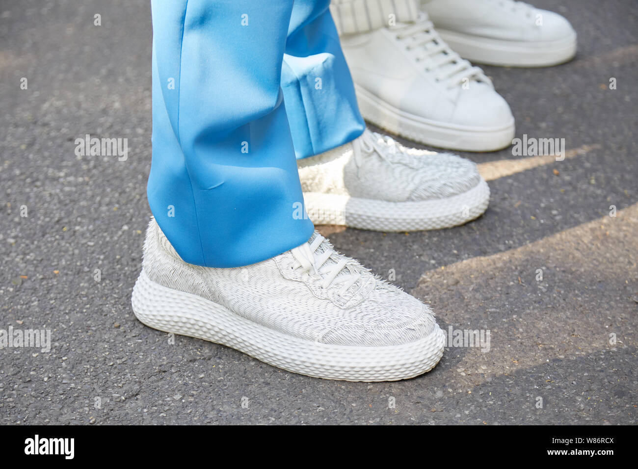 Milano, Italia - 17 giugno 2019: l'uomo con sneakers bianco e azzurro pantaloni prima di Fendi fashion show, la Settimana della Moda Milanese street style Foto Stock