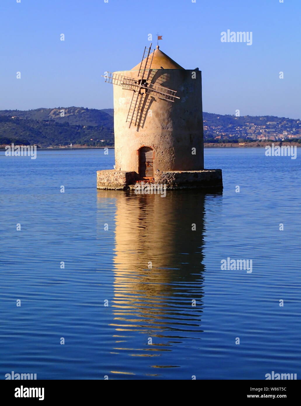Vecchio mulino a vento inclinata in acqua, Orbetello, Italia Foto Stock