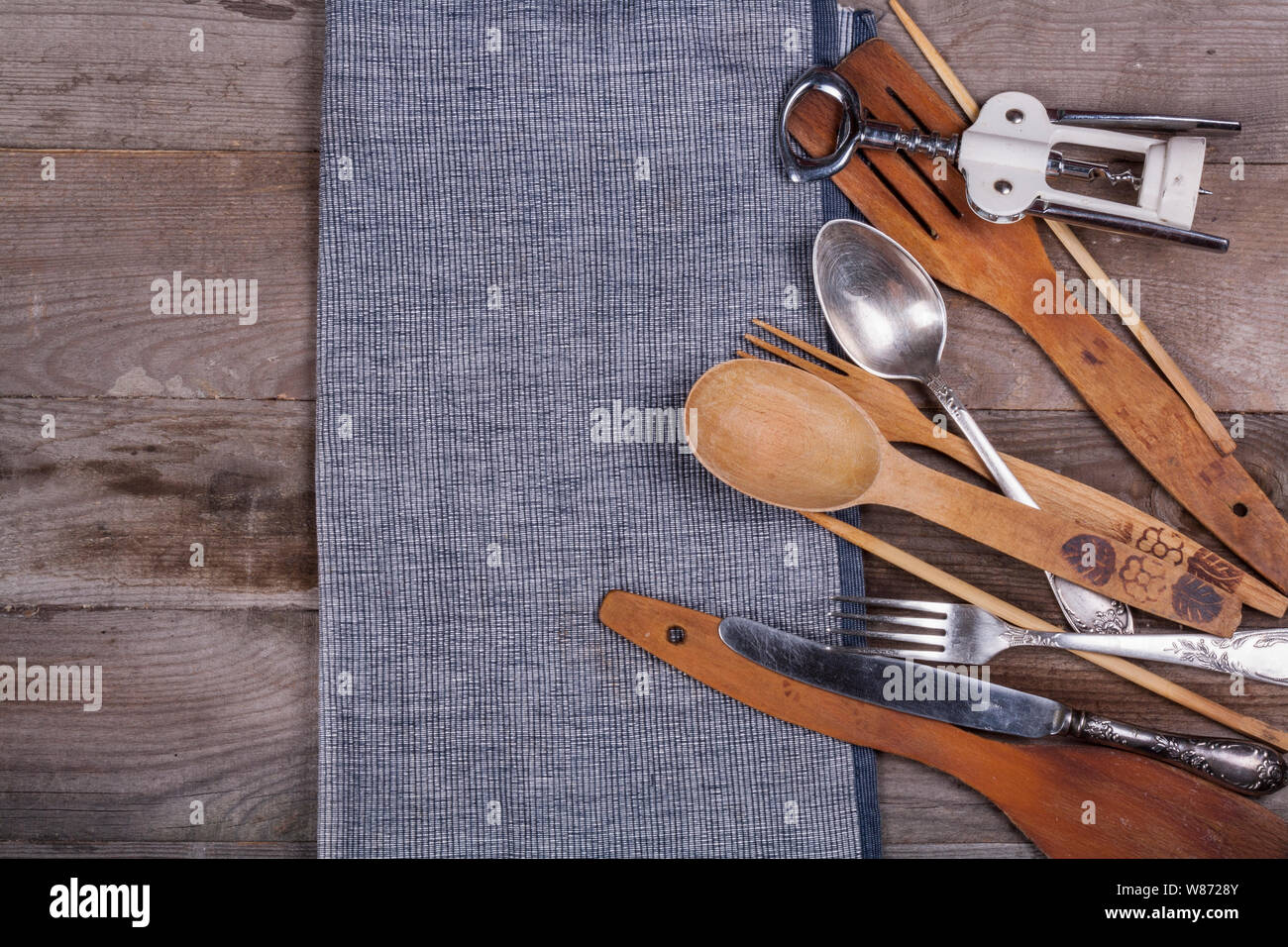 Cucina in legno utensili su una tavola di legno forcella cucchiaio cavatappi Foto Stock