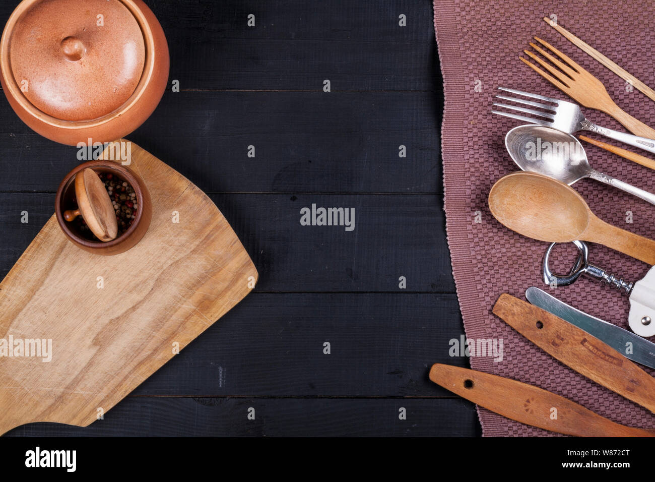 Cucina in legno utensili su una tavola di legno forcella cucchiaio cavatappi Foto Stock