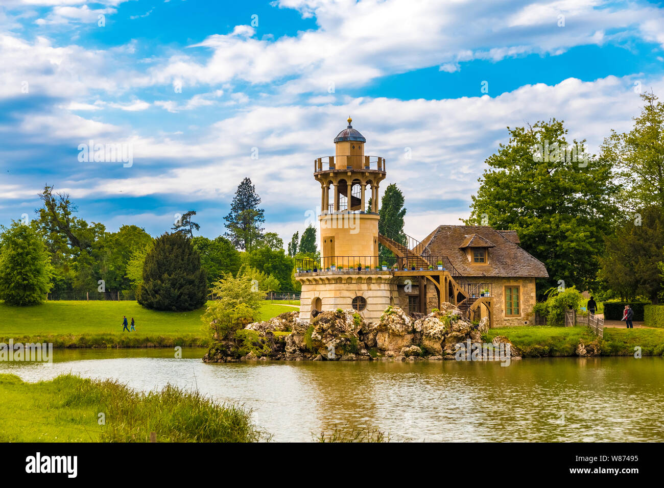 Paesaggio incantevole vista del Marlborough Torre che sovrasta il lago nel Casale della regina nel giardino di Trianon di Versailles. La torre decorativa... Foto Stock