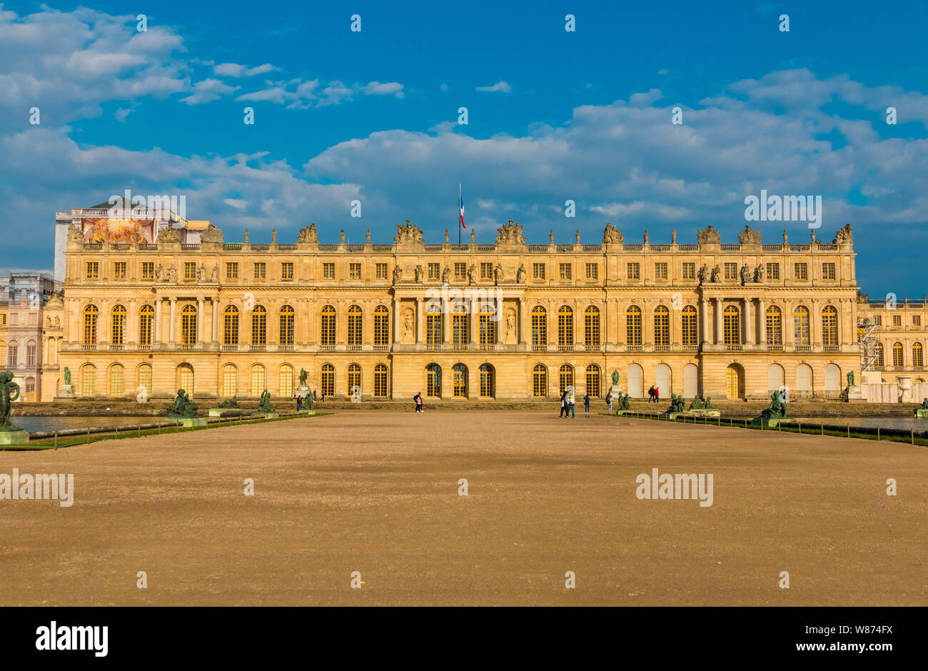 Tramonto indimenticabile vista panoramica della facciata ovest del palazzo di Versailles dal Parterre d'acqua con due piscine di forma rettangolare e un sentiero di ghiaia in... Foto Stock