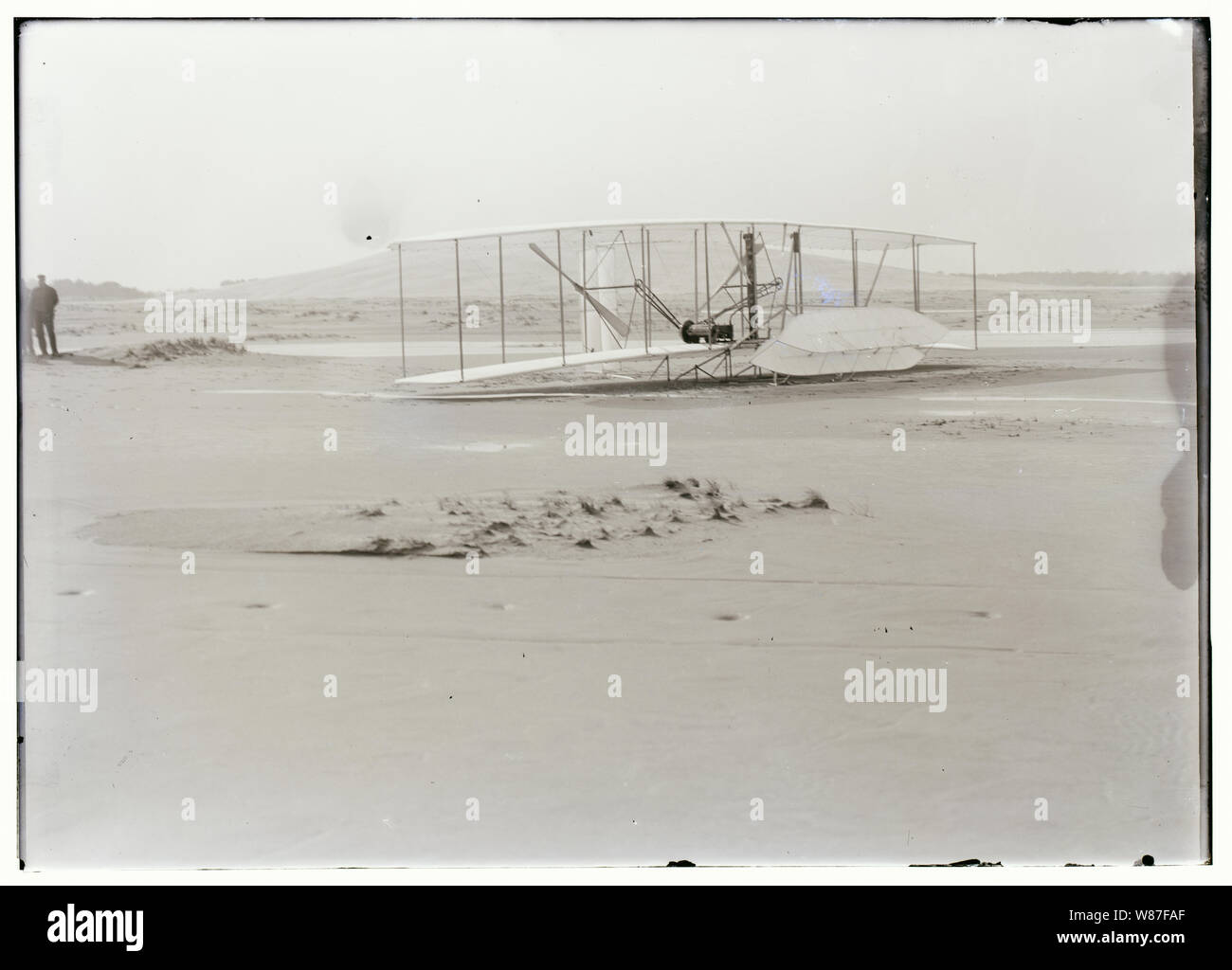 Vista ravvicinata del danneggiato 1903 Wright Flyer sul terreno dopo il suo quarto e ultimo volo su dicembre 17, 1903. Il flyer era atterrato il disco, rottura telaio del canale elevatore. Il Wrights aveva sperato di poter riparare rapidamente questo tipo di danni e di effettuare ulteriori voli di prova, ma un po' di tempo dopo che questa è stata scattata la foto, il Flyer è stato catturato e ribaltato da una raffica di vento, causando molto più gravi danni e di terminare la sua carriera di volo. Foto Stock