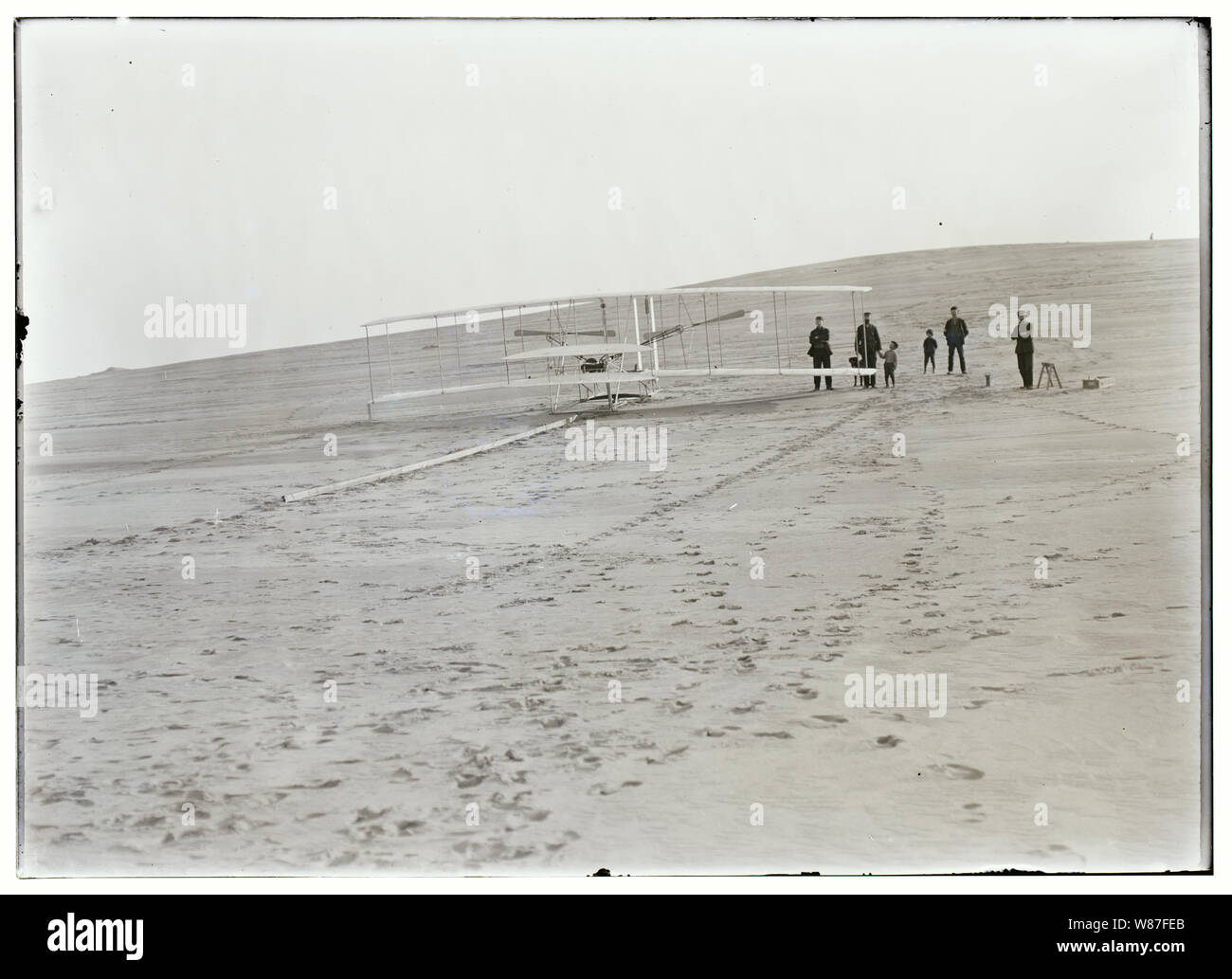 Il 1903 Wright Flyer sulla sua pista di lancio a Big Kill Devil Hill, Carolina del Nord, il 14 dicembre 1903, prima dell'Wrights' prima, fallito tentativo di volo. Quattro uomini dal Kill Devil Hills stazione salvavita ha contribuito a spostare il Flyer dal Wrights' sparso per la collina, accompagnato da due piccoli ragazzi e un cane. Foto Stock