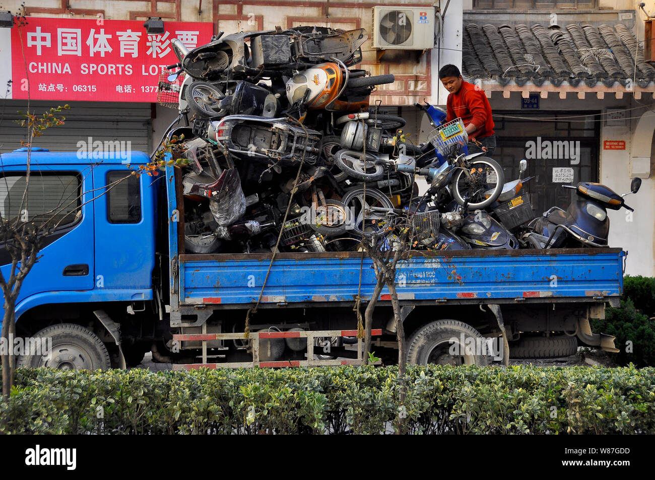 Rottami vecchi scooter elettrici vengono caricati per la presa di distanza di Nantong, Cina Foto Stock