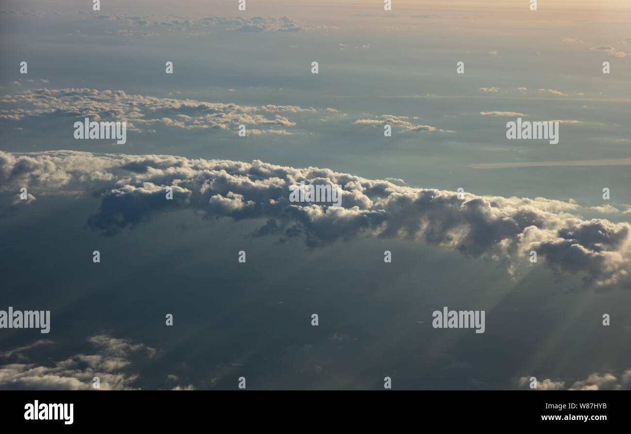 Cloudscape sfondo. Soffici nuvole al tramonto vista aerea al di fuori di un aeroplano finestra. Foto Stock