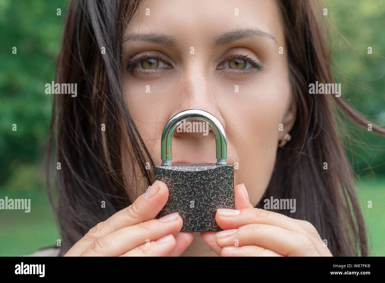 Ritratto concettuale di una donna di mantenere il silenzio con il dispositivo di bloccaggio sopra la sua bocca. donna caucasica Tieni la bocca bloccata. Lingua il concetto di barriera e la protezione di th Foto Stock