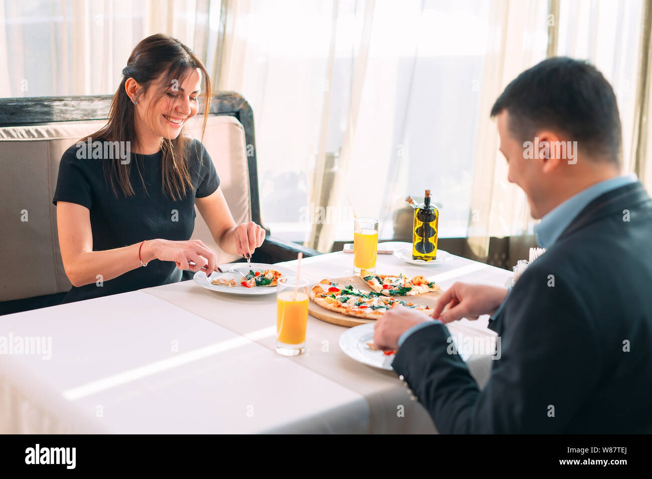 Un giovane mangia la pizza in un ristorante. Foto Stock