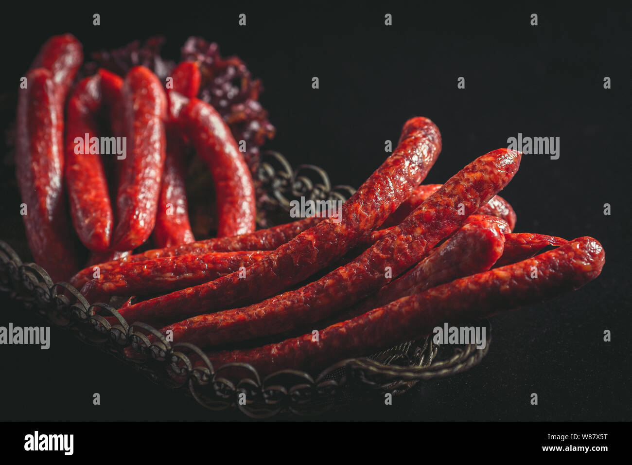 Caccia salsicce salsicce su uno sfondo scuro. Foto Stock