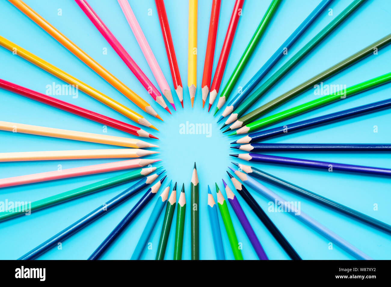 La condivisione delle idee concetto, matite multicolore su sfondo blu Foto Stock