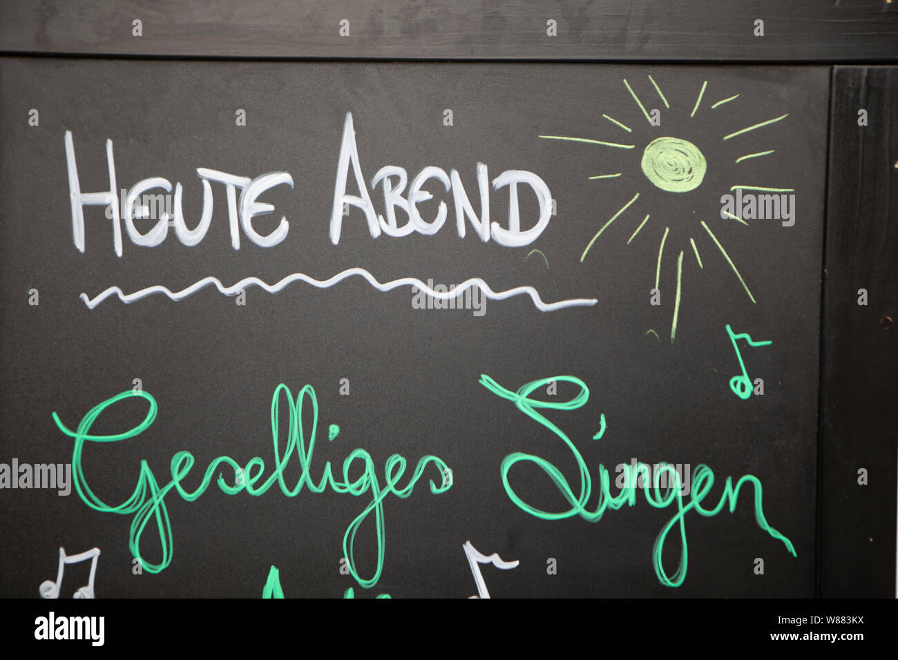 Annuncio di felice evento di canto scritto su una lavagna con Chalk Foto Stock