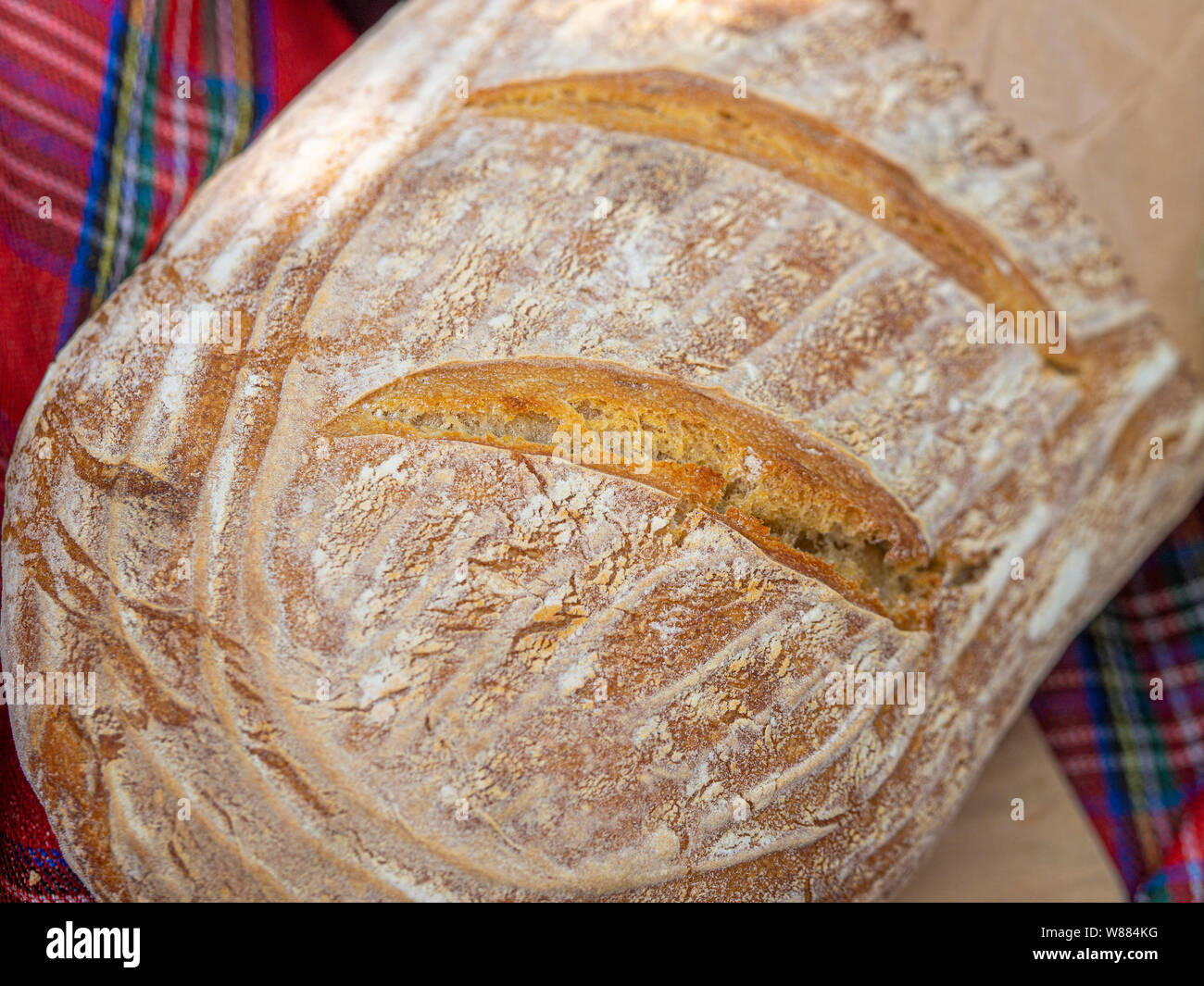Filone di pane fatto in casa con Coperta picnic in background Foto Stock