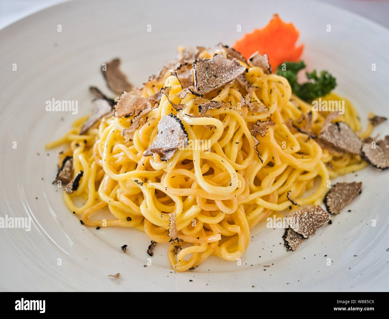 Pasta fatta in casa con i tartufi su una piastra bianca presentato con carote e broccoli Foto Stock