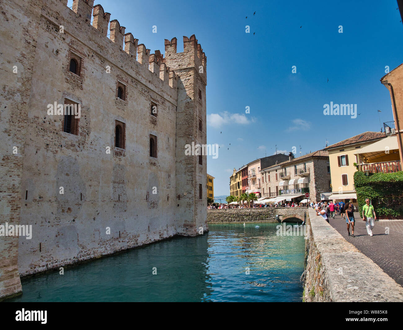 Canale di acqua e la parete laterale del Castello Scaligero nel villaggio di Sirmione sul Lago di Garda Foto Stock