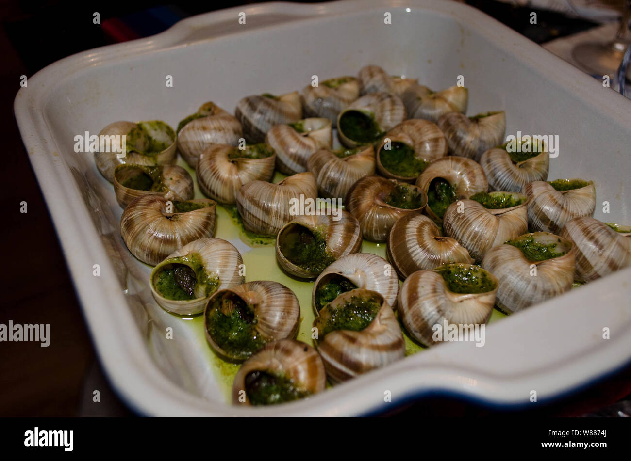 Escargots o lumache con aglio e prezzemolo e burro. Cucina tradizionale francese escargots in burro all'aglio. Foto Stock