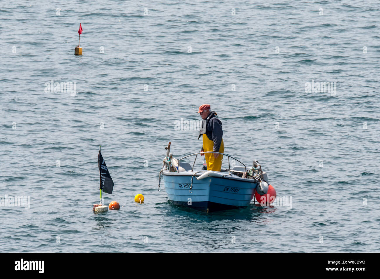 Pescatore in piccola barca da pesca la caduta / tiro trap aragosta / Lobster Pot / aragosta cantre nell'Oceano Atlantico / Canale Inglese Foto Stock