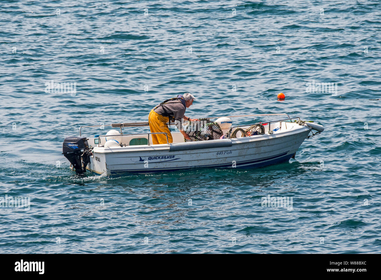 Pescatore in piccola barca da pesca la caduta / tiro trap aragosta / Lobster Pot / aragosta cantre nell'Oceano Atlantico / Canale Inglese Foto Stock